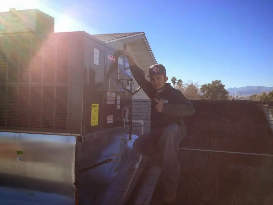 HVAC technician performing AC Tune-Up on a rooftop unit in Canton